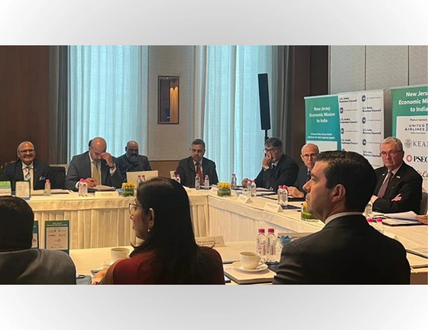 Group of people in a formal meeting setting with a conference table and chairs.